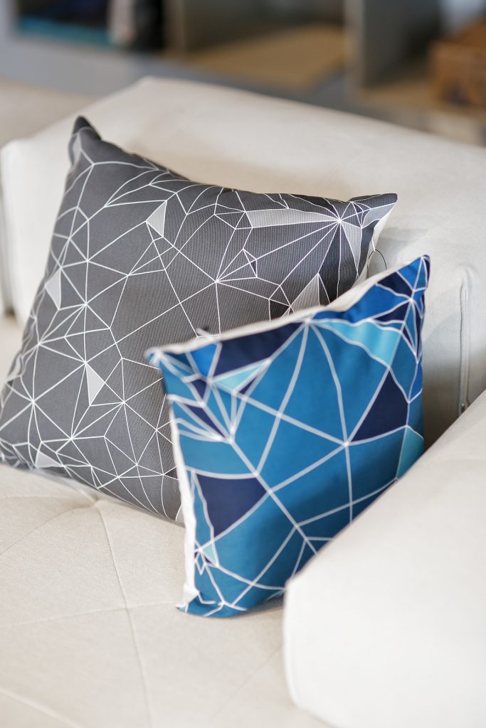 Almofadas nas cores azul e cinza sobre um sofá bege: mais uma dica simples de decoração 